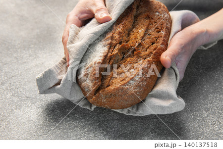 Hands holding freshly baked artisan rye bread Hands holding freshly baked artisan rye bread 140137518