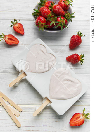 Preparing strawberry yogurt popsicles in heart shaped molds 140137539