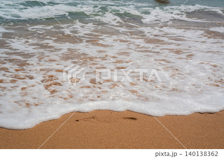 White sea foam spreads across a sandy beach in Sharm El Sheikh Egypt with shallow water along the Red Sea coastline. Beach resort lifestyle 140138362