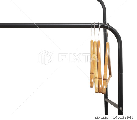 Wooden hangers stacked vertically on black metal rack corner. Garment holders aligned on horizontal bar. Interior storage scene for wardrobe, retail, organization concept.. Wooden hangers stacked vertically on black metal rack corner. Garment holders aligned on horizontal bar. Interior storage scene for wardrobe, retail, organization concept.. 140138949