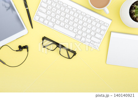 workspace with tablet, keyboard, coffee cup and eyeglasses copy space on yelow background. Top view. workspace with tablet, keyboard, coffee cup and eyeglasses copy space on yelow background. Top view. 140140921