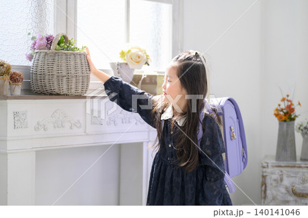 ランドセルを背負って花の入ったカゴを持つ日本人の女の子 ランドセルを背負って花の入ったカゴを持つ日本人の女の子 140141046