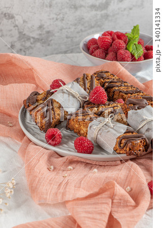Cereal bars with raspberries on kitchen counter top. 140141334