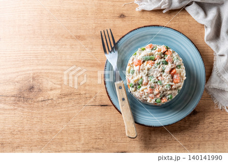 Traditional Russian salad served on plate over wooden table 140141990