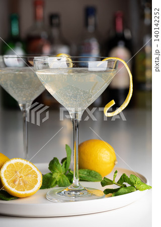 French 75 cocktails with lemon twist and mint on white tray French 75 cocktails with lemon twist and mint on white tray 140142252
