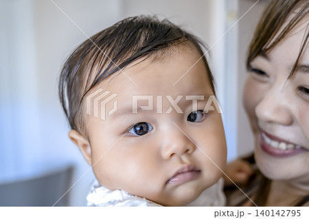 赤ちゃんを抱く笑顔の母親と乳児 140142795