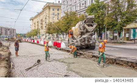 Concrete works for road maintenance construction with many workers and mixer machine timelapse Concrete works for road maintenance construction with many workers and mixer machine timelapse 140143405