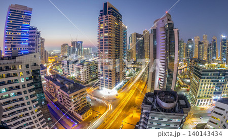 Aerial view of Dubai Marina after sunset from a vantage point day to night timelapse. 140143434