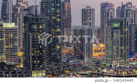 Luxury Dubai Marina canal with passing boats and promenade day to night timelapse, Dubai, United Arab Emirates 140143445