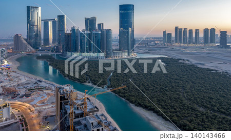 Buildings on Al Reem island in Abu Dhabi day to night timelapse from above. 140143466