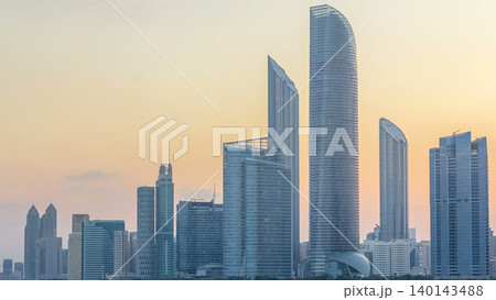 Abu Dhabi city skyline with skyscrapers before sunrise with water reflection night to day timelapse Abu Dhabi city skyline with skyscrapers before sunrise with water reflection night to day timelapse 140143488