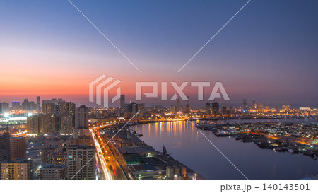 Cityscape of Ajman from rooftop day to night timelapse after sunset. 140143501