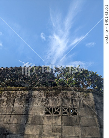 苔むしたブロック塀と瓦屋根越しに見上げる夏の青空 140143651