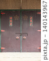 神社の神輿庫の重厚な扉・家紋と赤い装飾金具 140143967
