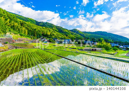 【山梨県】南アルプス市 田植えが済んだ中野の棚田 水田に映る青空 【山梨県】南アルプス市 田植えが済んだ中野の棚田 水田に映る青空 140144108