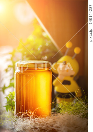Honey in glass jars with flowers background. Honey in glass jars with flowers background. 140144287