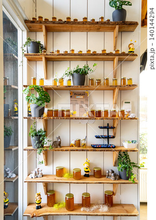 Natural honey in various jars on a wooden shelf, souvenir village market. 140144294