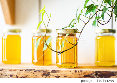 Natural honey in various jars on a wooden shelf, souvenir village market. 140144299