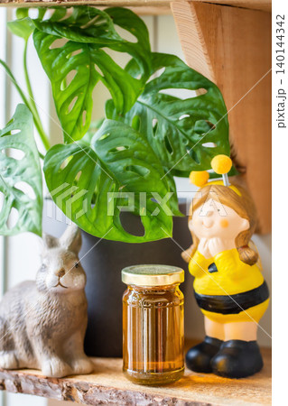 Natural honey in various jars on a wooden shelf, souvenir village market. Natural honey in various jars on a wooden shelf, souvenir village market. 140144342