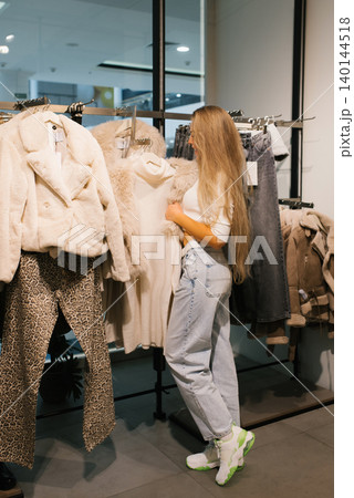 Customer Looking at Clothes in Modern Shop 140144518