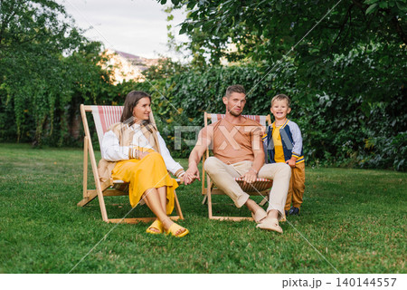 Happy Family With Pregnant Mother Sitting Outdoors 140144557