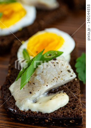 Marinated herring fillet served on rye bread toast Marinated herring fillet served on rye bread toast 140144858