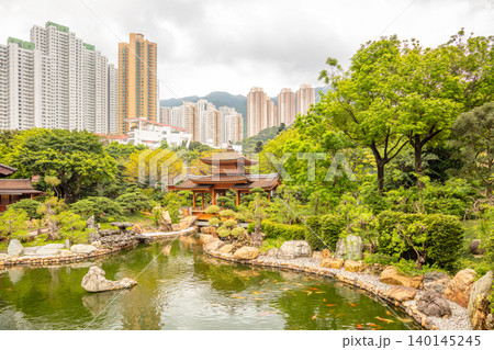 Ancient Wooden Pavilion on a Pond and Hong Kongs Skyscrapers 140145245
