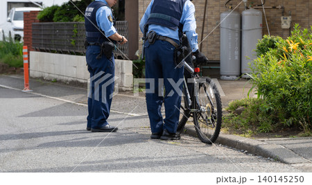 自転車を確認する警察官 140145250