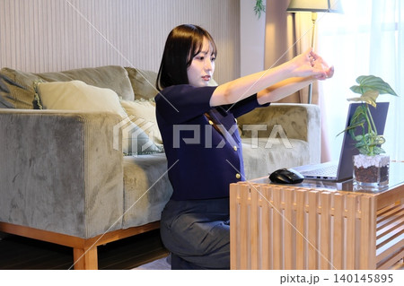 リモートワークの休憩時にとストレッチでリフレッシュする女性 リモートワークの休憩時にとストレッチでリフレッシュする女性 140145895
