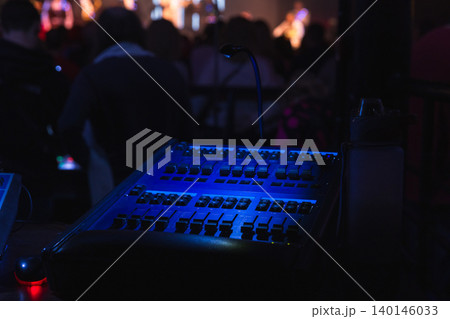 Blue-lit soundboard and lighting control desk Blue-lit soundboard and lighting control desk 140146033