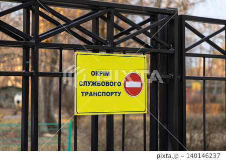 A bright yellow traffic sign is mounted on a black metal gate to prohibit general entry while permitting only service vehicles to pass in this restricted private access area A bright yellow traffic sign is mounted on a black metal gate to prohibit general entry while permitting only service vehicles to pass in this restricted private access area 140146237