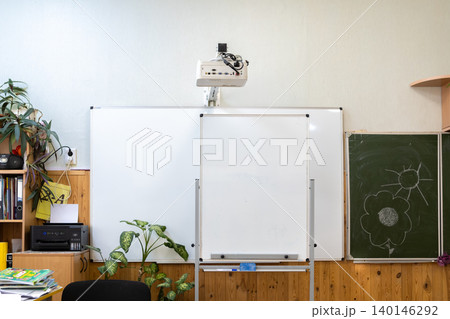 Modern multimedia classroom with empty white boards and digital projector mounted on wall representing educational facility and academic environment for professional teaching training 140146292