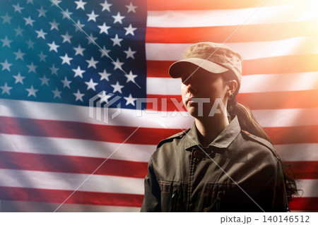 Memorial Day, Independence Day. Portrait of A female soldier in uniform, against the background of the American flag. The concept of the American national holidays and patriotism 140146512