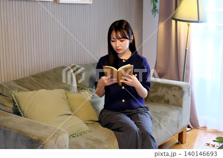 至福のインドア休日。柔らかな光に包まれて本を楽しむ、洗練された大人のリラックスタイム 140146693