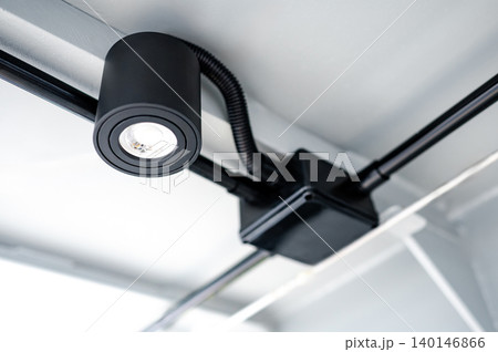 Modern black cylindrical downlight or cylinder LED spotlight hanging on the ceiling 140146866