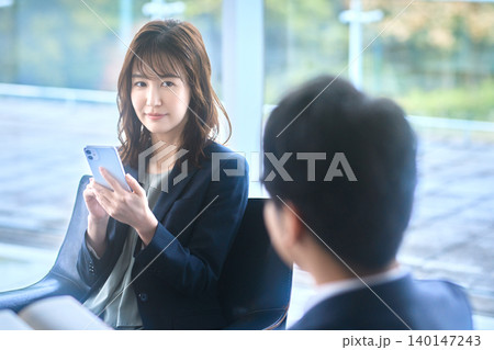 スマートフォンで提案する日本人ビジネスウーマンと顧客 スマートフォンで提案する日本人ビジネスウーマンと顧客 140147243