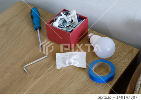 Tools and materials arranged on a wooden table for a home repair project Tools and materials arranged on a wooden table for a home repair project 140147807
