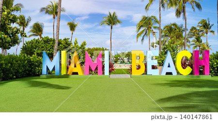 Miami beach sign. Miami beach sign text surrounded with tropical palm tree in summer vacation in exotic Florida Miami beach sign. Miami beach sign text surrounded with tropical palm tree in summer vacation in exotic Florida 140147861