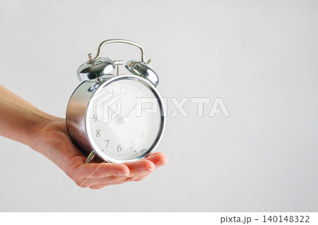 Hand holding alarm clock, time management deadline productivity and planning concept 140148322