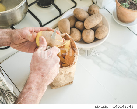 Man's hands peel a potato Man's hands peel a potato 140148343
