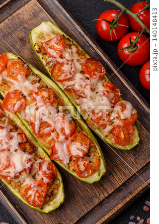 Baked zucchini half with minced meat, tomatoes, cheese, salt, and spices. Zucchini with minced meat Baked zucchini half with minced meat, tomatoes, cheese, salt, and spices. Zucchini with minced meat 140148413