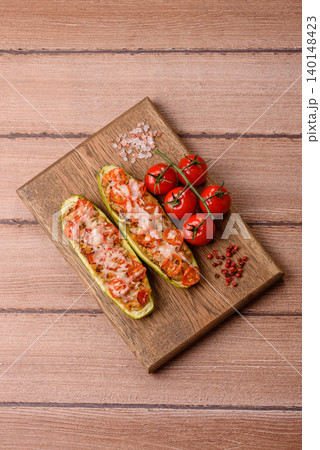 Baked zucchini half with minced meat, tomatoes, cheese, salt, and spices. Zucchini with minced meat Baked zucchini half with minced meat, tomatoes, cheese, salt, and spices. Zucchini with minced meat 140148423