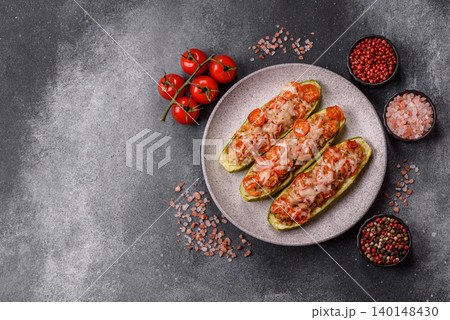 Baked zucchini half with minced meat, tomatoes, cheese, salt, and spices. Zucchini with minced meat 140148430