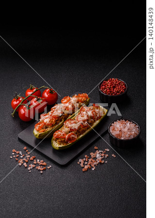Baked zucchini half with minced meat, tomatoes, cheese, salt, and spices. Zucchini with minced meat Baked zucchini half with minced meat, tomatoes, cheese, salt, and spices. Zucchini with minced meat 140148439