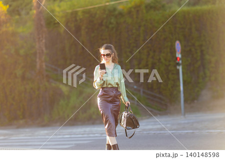 Modern Business Woman Using Smartphone on City Crosswalk Modern Business Woman Using Smartphone on City Crosswalk 140148598