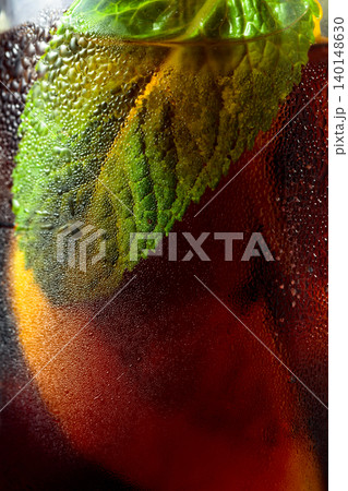 Cocktail with lemon, ice and mint in misted glass. 140148630