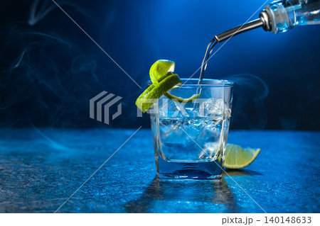 Vodka with lime and ice cubes in a fogged up glass. Vodka with lime and ice cubes in a fogged up glass. 140148633