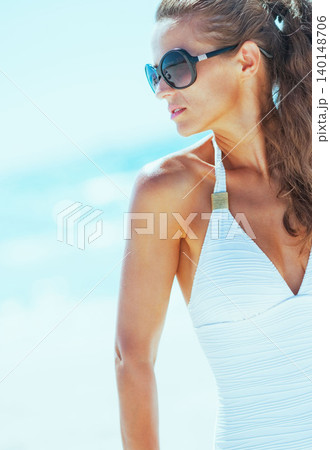 Young woman in swimsuit on beach looking on copy space Young woman in swimsuit on beach looking on copy space 140148706