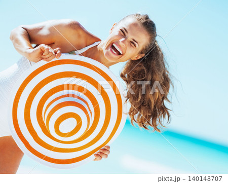 happy young woman in swimsuit with beach hat having 140148707