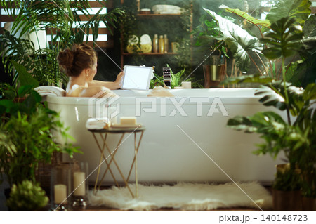 Woman Unwinding with Tablet in a Lush Spa Bath Woman Unwinding with Tablet in a Lush Spa Bath 140148723